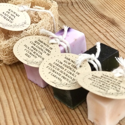 Sabonetes artesanais quadrados com etiquetas em cordão sobre madeira