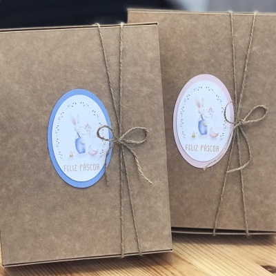 Caixas de papelão castanho com rótulos ovais de Páscoa e cordão de sisal