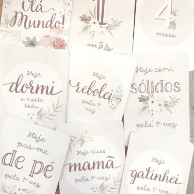 Cartões de marcos de bebé com frases e ilustrações florais em cores suaves.