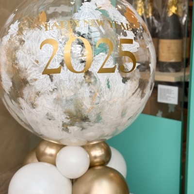 Balão decorativo transparente com texto dourado 2025 e balões brancos e dourados