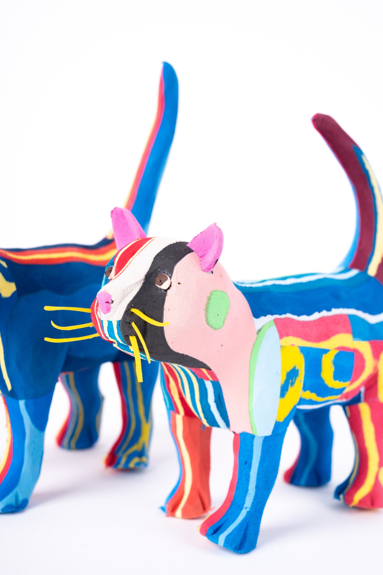 Gato M Esculturas de gatos coloridos em tecido com padrões listrados e manchas