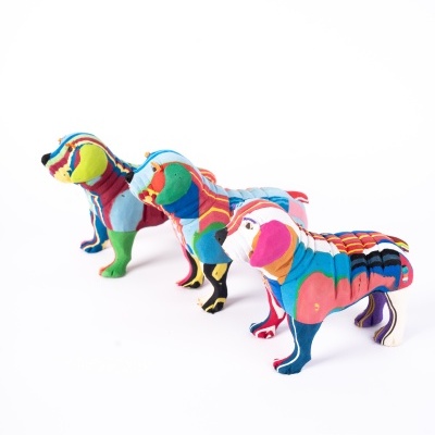 Esculturas de cães coloridas em tecido com padrões variados sobre fundo branco