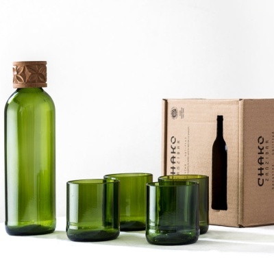 Conjunto de garrafa verde, copos de vidro e caixa de papelão reciclado