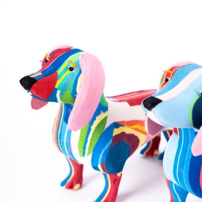 Estatuetas de cães coloridos em tecido com várias cores e orelhas rosa