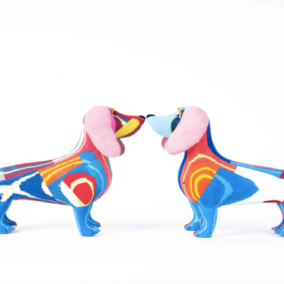 Estátuas de cães coloridos em tecido sobre fundo branco