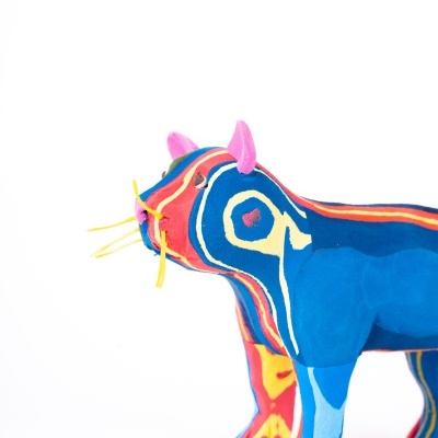 Figura de animal em tecido colorido com padrões abstratos e bigodes amarelos