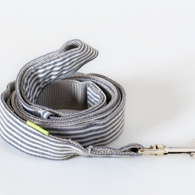 Trela de tecido com riscas cinzentas e brancas e presilha metálica