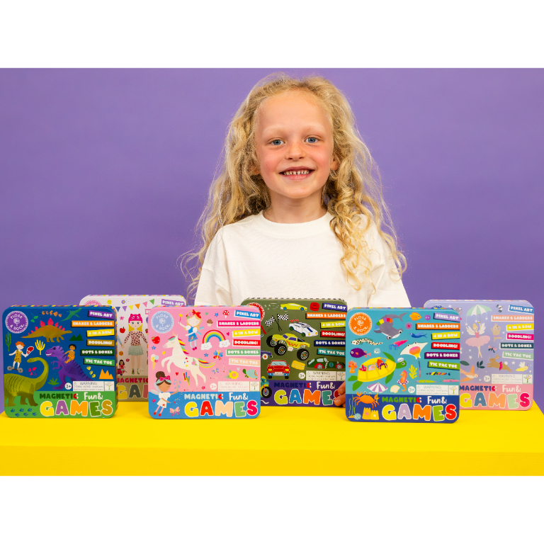 Criança com camisola branca apresenta caixas de jogos magnéticos coloridos