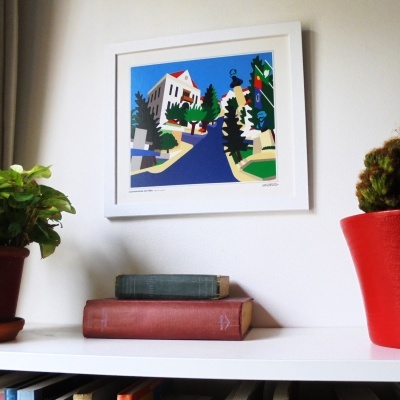 Quadro colorido de rua inclinada com plantas em vasos e livros numa prateleira branca