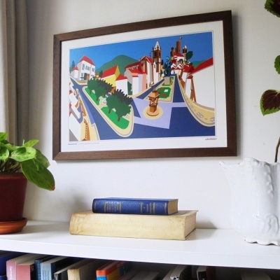 Quadro colorido com ilustração de cidade, moldura em madeira castanha