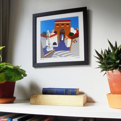 quadro emoldurado com arte moderna colorida de edifícios e figuras, plantas em vasos e livros numa prateleira branca