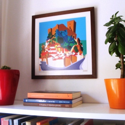 Estante branca com livros, vasos coloridos e quadro de castelo colorido na parede