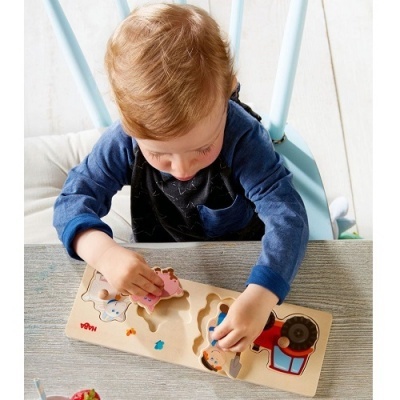 Criança a brincar com puzzle de madeira de animais