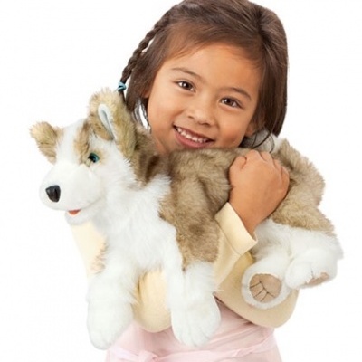 Menina sorridente a segurar peluche cão husky siberiano cinzento e branco