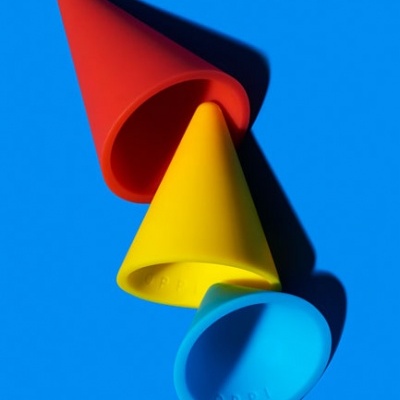 Três cones de silicone vermelho, amarelo e azul sobre fundo azul