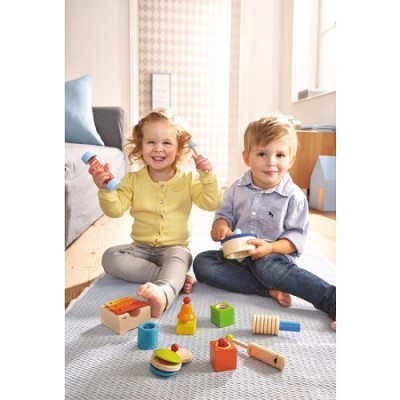 Duas crianças a brincar com brinquedos de madeira coloridos num tapete cinza