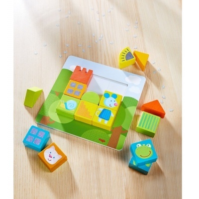 Blocos de madeira coloridos para montar figuras sobre base com desenho de relva e céu