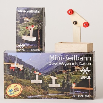 Kit Mini-Seilbahn em madeira com embalagens e texto em alemão