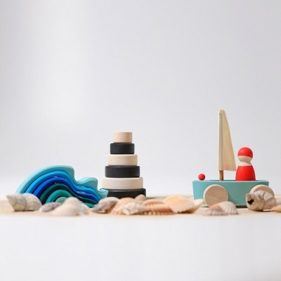 Brinquedos de madeira coloridos com conchas naturais no fundo branco.