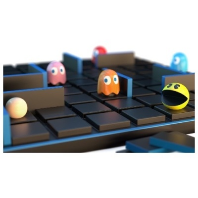 Tabuleiro preto de jogo com personagens esféricos do Pac-Man num labirinto