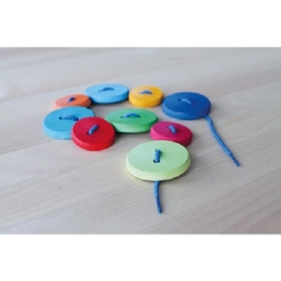 Botões de madeira coloridos com cordel azul sobre superfície de madeira clara