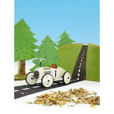 Carrinho de corrida vintage branco num cenário com estrada, colina verde e árvores de papel