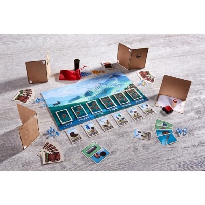 Jogo de tabuleiro com cartas, peões azuis, cubos de madeira, saco vermelho e tabuleiro colorido sobre mesa clara