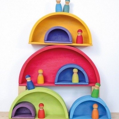 Brinquedos de madeira coloridos em arcos com figuras humanas pintadas