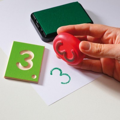 Carimbo em forma do número 3 vermelho com almofada de tinta verde e placa recortada do número 3