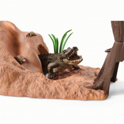 Figura decorativa de crocodilo com plantas e tartarugas numa base texturada