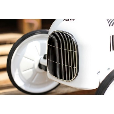 Brinquedo de metal branco com rodas grandes de plástico preto e branco.