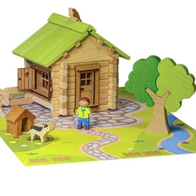 Brinquedo em madeira representando uma casa com telhado verde, boneco, cão, árvore e riacho