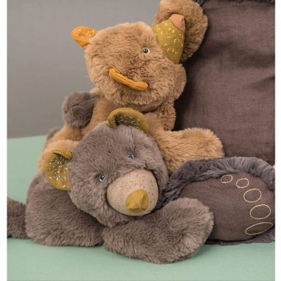 Dois ursinhos de pelúcia, castanho claro e cinza, sobre superfície verde e almofada castanha