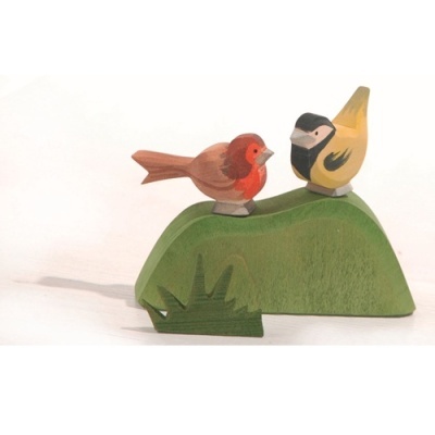 Estatuetas de madeira de dois pássaros coloridos sobre base verde