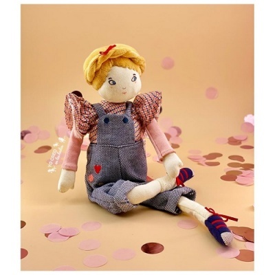 Boneca de pano sentada com roupa colorida e fundo bege com círculos de papel