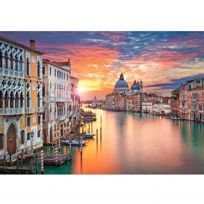 Canal veneziano ao pôr do sol com edifícios históricos e céu colorido