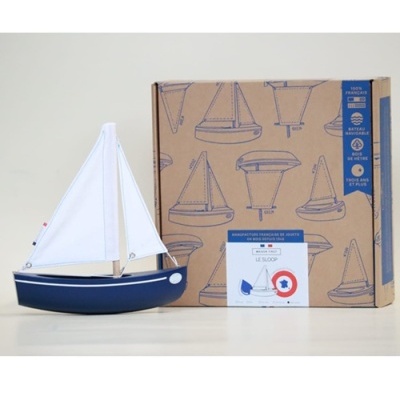 Barco de vela decorativo azul escuro com vela branca e caixa com ilustrações de barcos