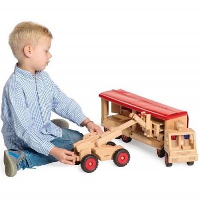 Criança brincando com brinquedos de madeira e cobertura vermelha