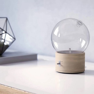 Abajur de base madeira e cúpula redonda translúcida sobre mesa branca