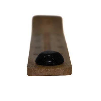 Tabuleiro de madeira clara com peça preta arredondada em foco