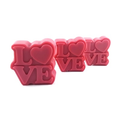 Sabonetes rosa com palavra LOVE e coração em fundo branco