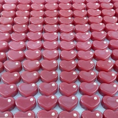 Pequenos objetos em forma de coração rosa escuro com dois pontos brancos