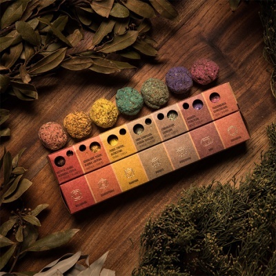 Conjunto de caixas coloridas com bolas aromáticas sobre madeira e folhas