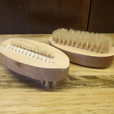 Escovas de madeira com cerdas naturais sobre superfície de madeira.