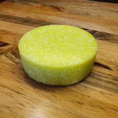 Sabonete redondo amarelo sobre madeira