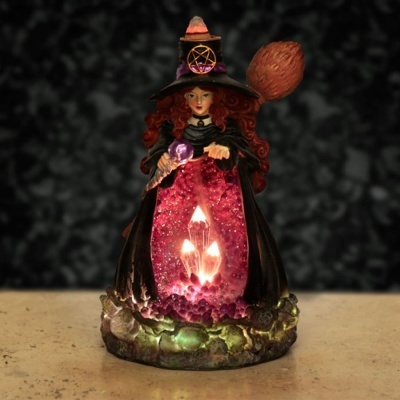 Figura decorativa de bruxa com cristais e base iluminada