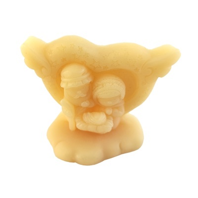 Escultura ou vela amarela em forma de anjo com dois personagens infantis sentados