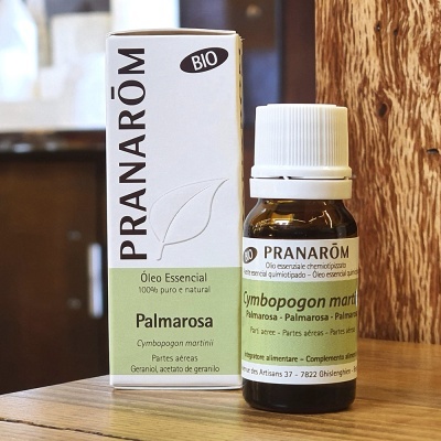 Frasco e caixa do óleo essencial Pranarôm Palmarosa em mesa de madeira