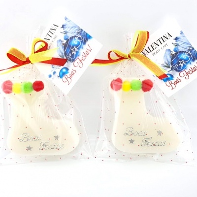 Dois biscoitos em forma de meia de Natal decorados e embalados com etiquetas e laços