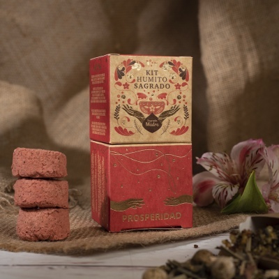 Kit Humito Sagrado em embalagem vermelha e bege com três pastilhas vermelhas empilhadas e flor rosa
